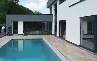 maison avec crépi blanc sur façade, piscine et terrasse en bois