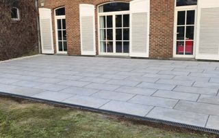 maison avec terrasse en pierres naturelles et volets blancs