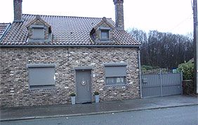 maison avec porte d'entrée et volets roulants gris