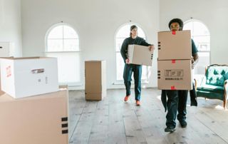 hommes qui porte des cartons de déménagement