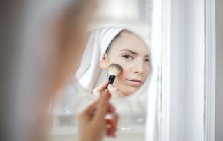 femme se maquillant devant un miroir