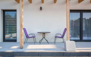 terrasse en pierre naturelle avec chaises de jardin mauves