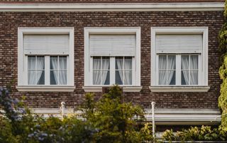 trois fenêtres sur une maison en briques